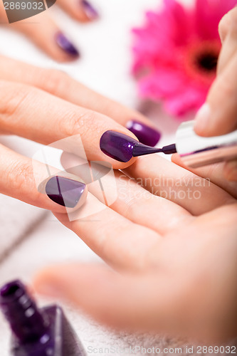 Image of Woman having a nail manicure in a beauty salon