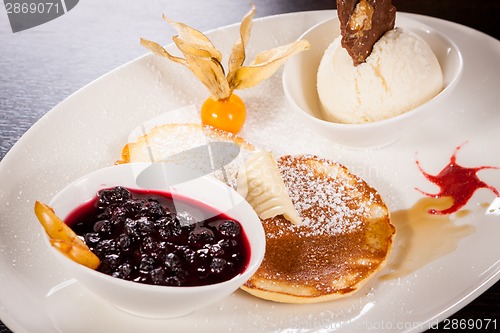 Image of tasty sweet pancakes with vanilla icecream and topping