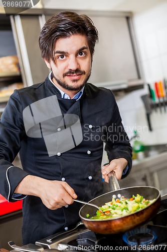 Image of Chef cooking a vegetables stir fry over a hob