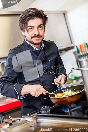 Image of Chef cooking a vegetables stir fry over a hob