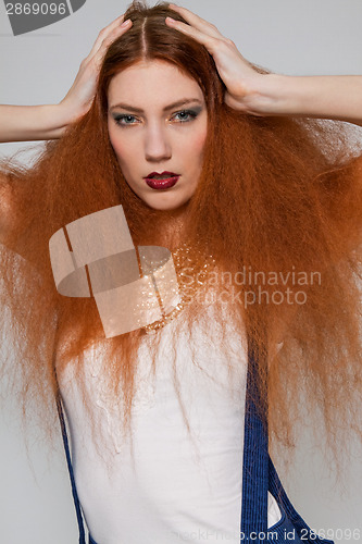 Image of Female model playing with frizzy hair