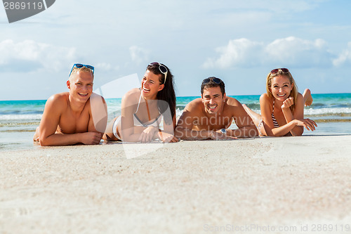 Image of young happy friends havin fun on the beach