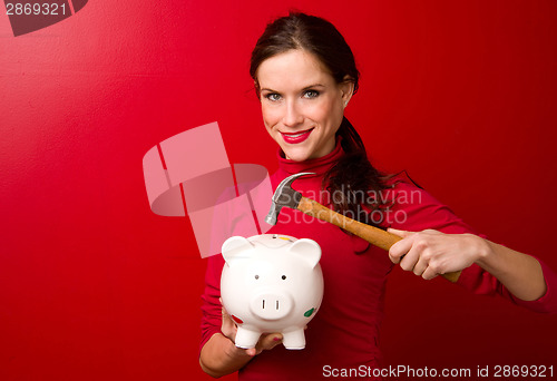 Image of Woman in Red Starts to Break the Piggy Bank with Hammer