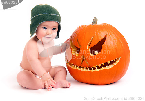 Image of Young Boy Sits in Diaper with Carved Halloween Pumpkin