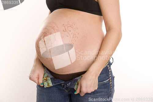 Image of Pregnant Female Belly with Temporary Henna Design Tattoo