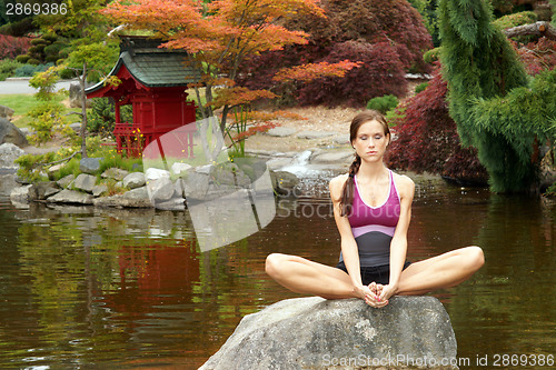 Image of Healthy woman practices Yoga in beautiful Yoga Pond