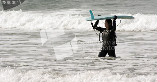 Image of Serious Surf Boarder Female Carries her Surfboard through Surf