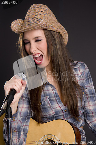 Image of Cowgirl Singer Belts out Tune Yelling Singing into Microphone