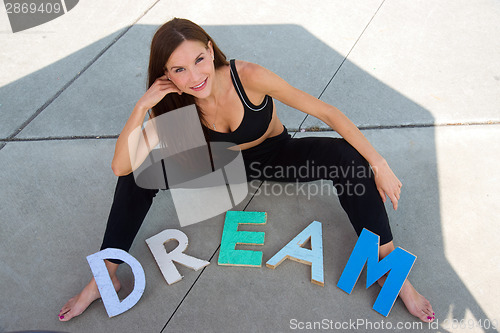 Image of Dream in Block Letters on Ground in Front of Attractive Woman Ou