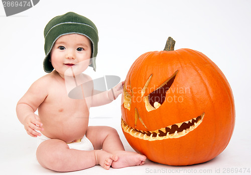 Image of Happy Six Month Old Boy Sitting in Diaper With Carved Halloween 