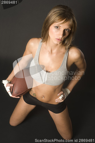 Image of Football Player Woman Tucks Balll to her Torso