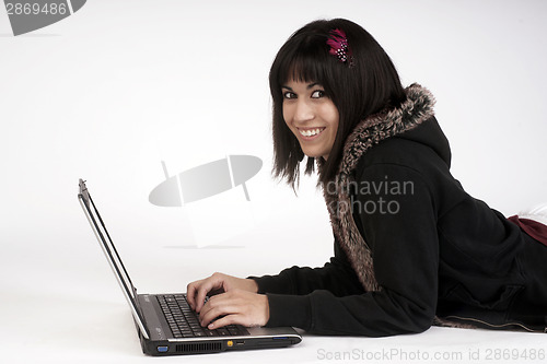 Image of Woman Types Work on Laptop Computer Laying on Floor