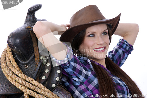 Image of Cowgirl Relaxes Leaning on Saddle and Rodeo Gear