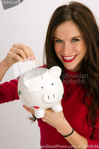 Image of Save a Quarter Smiling Woman Drops Quarter into Piggy Bank
