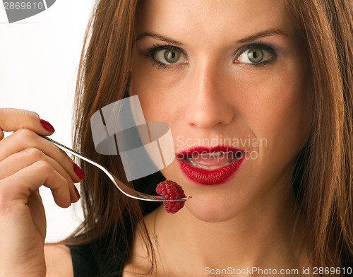 Image of Woman eats RAW fruit Food Raspberry on Fork