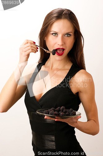 Image of Woman eats RAW fruit Food Blackberries