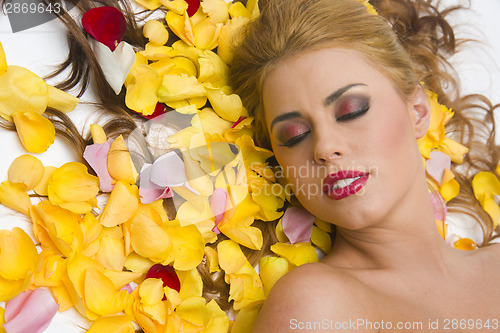 Image of Woman at Rest in Flower Petals Yellow Roses Floral Scene