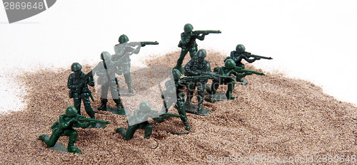 Image of Toy Army Men in Pile of Sand
