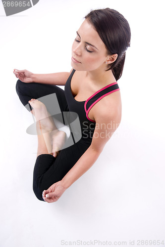 Image of Happy woman seated meditation pose on White