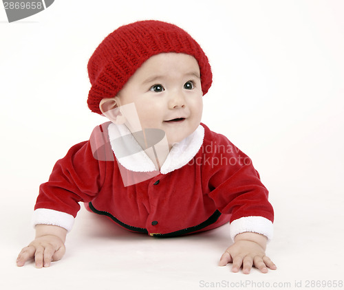 Image of Infant Boy Sits up on Hands LOOKING out under his red hat