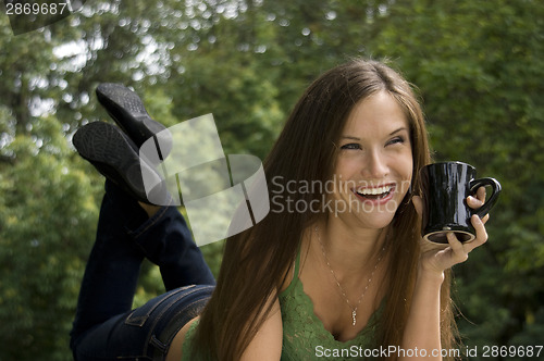 Image of Happy Attractive Woman Enjoys Coffee in the Park