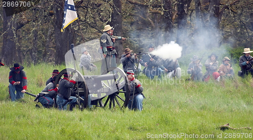 Image of Civil War Re-enactment Confederate Soldiers Fire Rifles During B