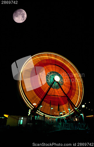 Image of Fair Moon Full Lunar Showing over Local Fair Midway Canival Ride