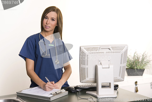 Image of Working Nurse Fills Out Chart at Workstation