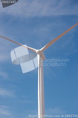 Image of Wind Power Generator With Moon and Blue Sky Background