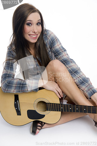 Image of Attractive Happy Female Musician on Floor Holding Acoustic Guita