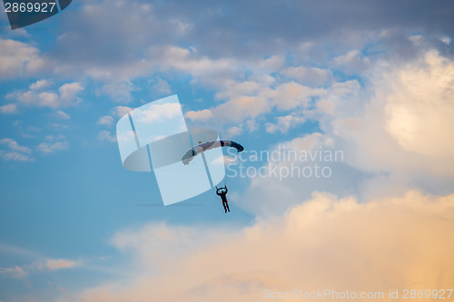 Image of unidentified skydiver, parachutist on blue sky