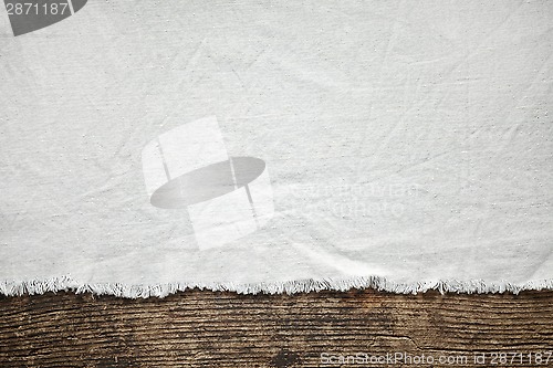 Image of old white cotton tablecloth on wooden table