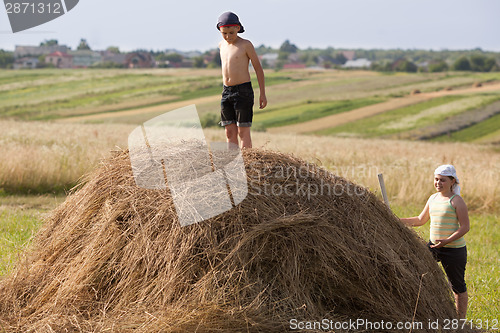 Image of Children and hay on field in sunset