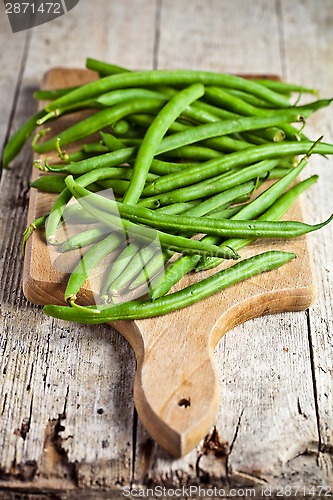 Image of green string beans on wooden board