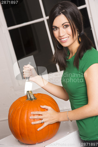 Image of Happy Attractive Woman Cuts Top Off Pumpkin Halloween Jackolante