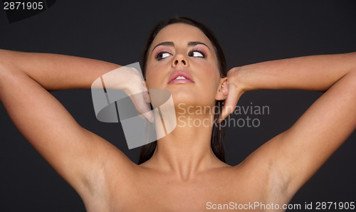 Image of Woman Looks to The Side While Dressing and Creating Hairstyle