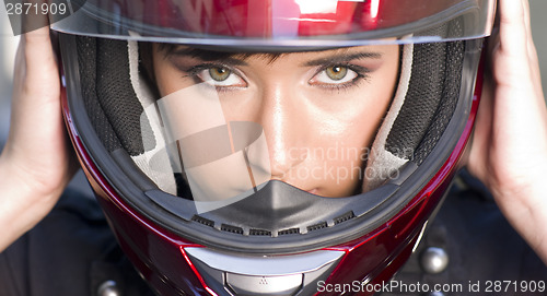 Image of Attractive Girl Positions Red Full Face Helmet Before Motorcycle