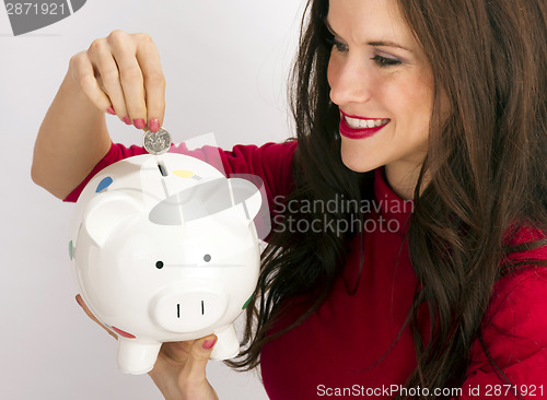 Image of Pretty Happy Brunette Woman Drops Quarter Coin Savings Bank