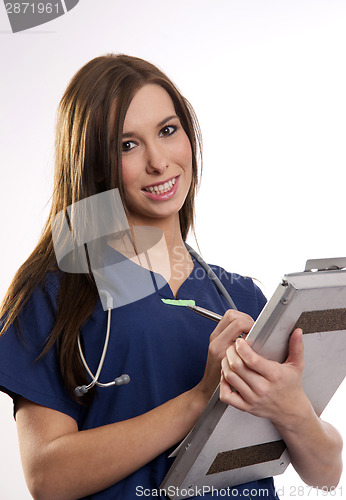 Image of Beautiful Brunette Nurse Records Patient Medical Chart Data on C