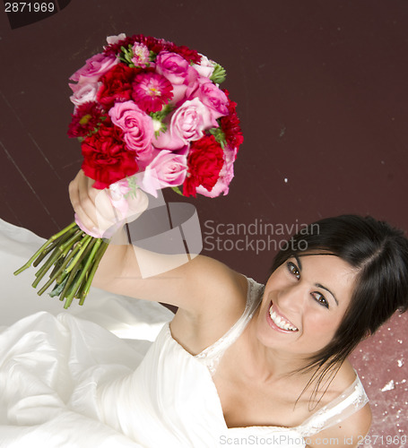 Image of Bouquet Raised in Air By Bride Wearing White Wedding Gown