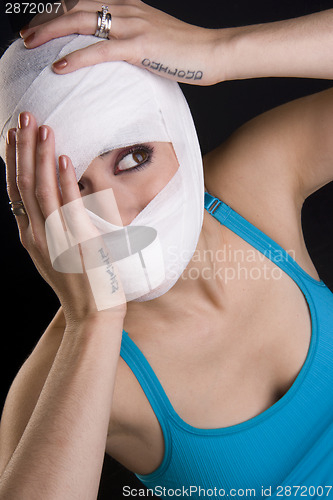 Image of Female Holds Face First Aid Gauze Wrapped Head Injury Pain