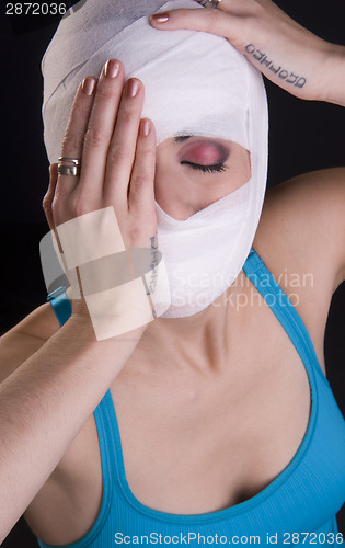 Image of Female Holds Face First Aid Gauze Wrapped Head Injury Pain