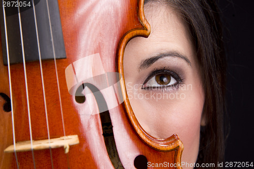 Image of Beautiful Female Face Behind Colorful Musical Violin