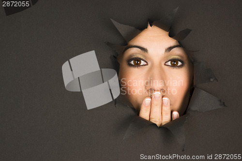 Image of Beautiful Brunette Woman Looks Through Torn Hole Hand Covers Mou