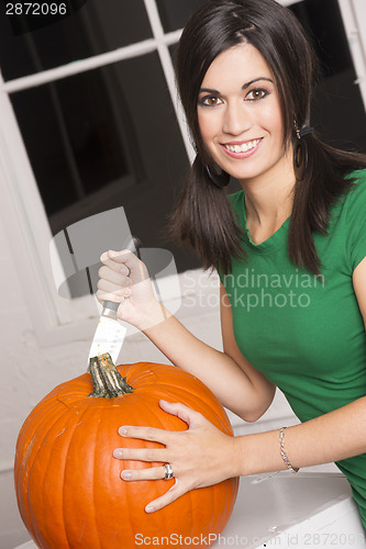 Image of Excited Woman Cutting Carving Halloween Pumpkin Jack-O-Lantern