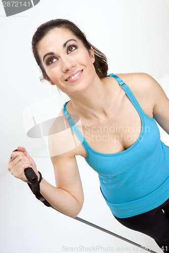 Image of Beautiful Brunette Woman Tones Muscles Working Out Tension Band