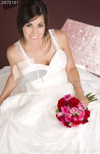 Image of Bride Sitting in White Wedding Dress with Flower Bouquet Red Ros