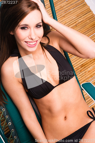 Image of Lounging Woman Sunbathing Lawn Chair Bamboo Floor Black Bikini