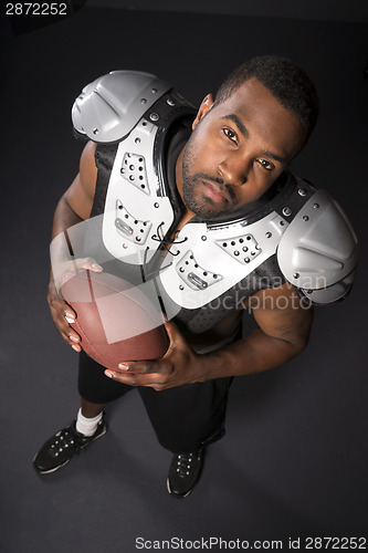 Image of African American Man Football Player Shoulder Pads Looking at Ca