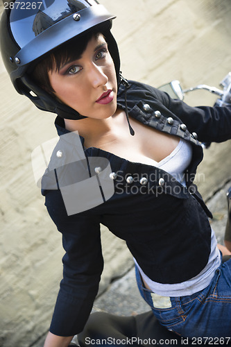 Image of Sassy Young Woman Sitting Sideways on Motorcycle Seat in Alley